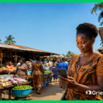 West African woman using a smartphone to file a complaint at an open-air market, illustrating how ERCA's complaint management system gives 400 million ECOWAS consumers access to digital grievance redress